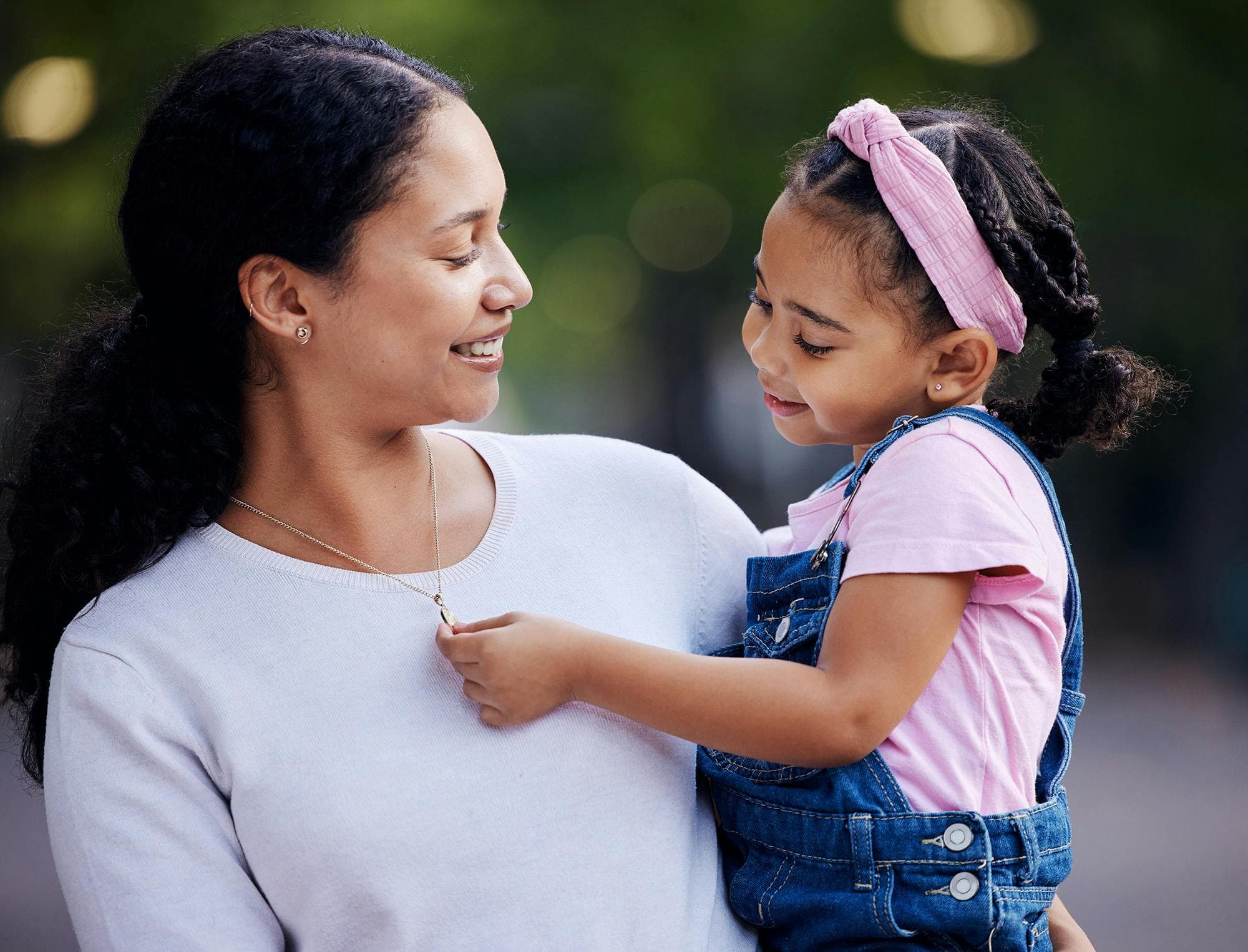 daughter admiring mother's gold necklace