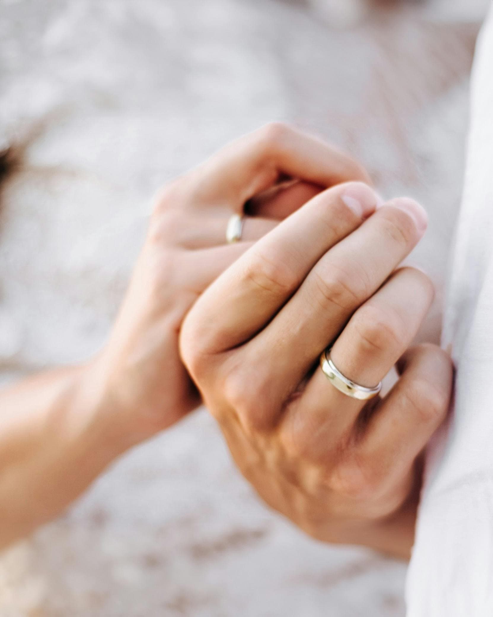 Hands of bride and groom wearing wedding bands